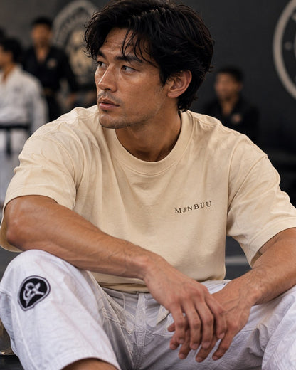 Beige MJNBUU tee worn in a jiu-jitsu gym